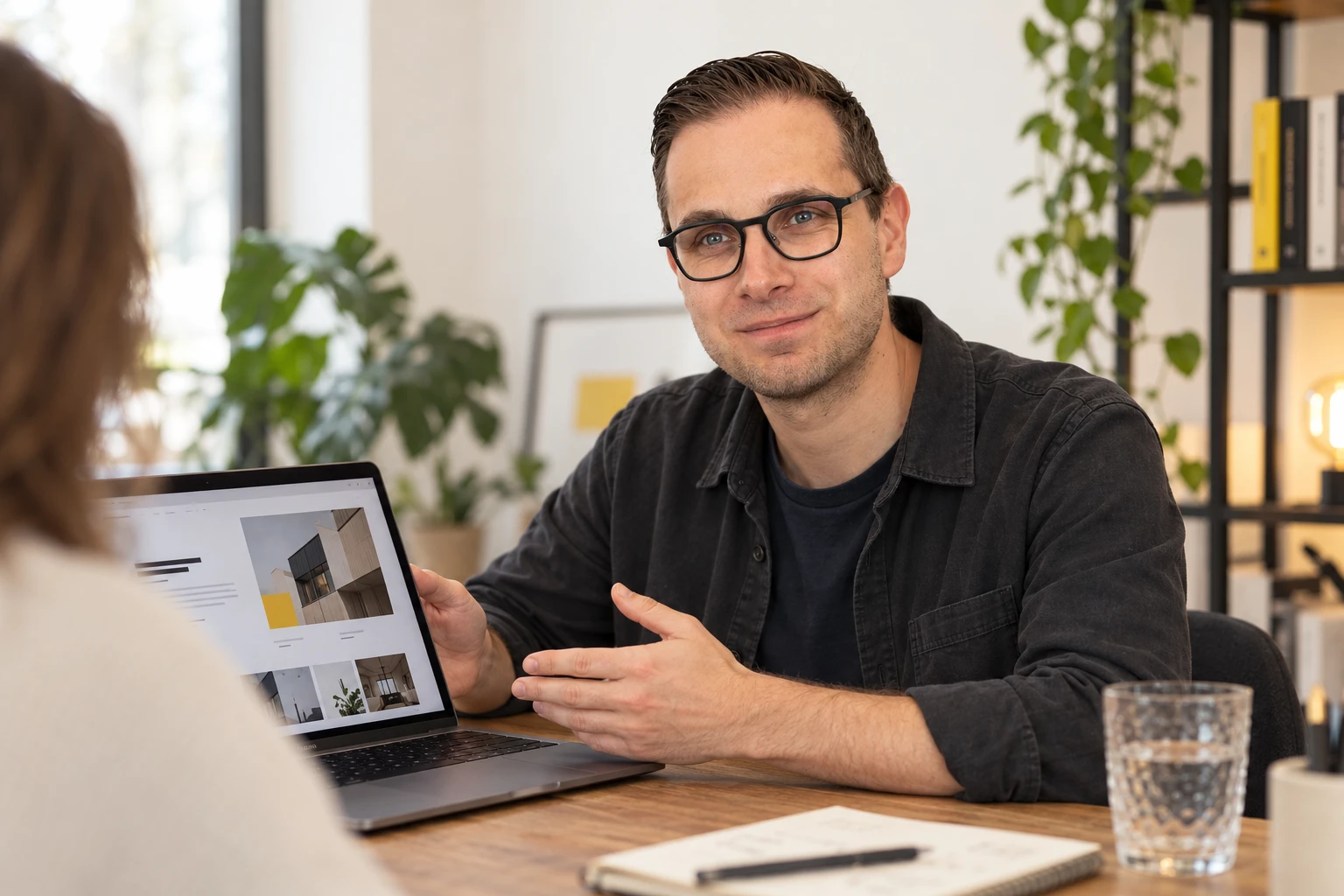 Wesley Eeckhout bespreekt een websiteontwerp op een laptop met een klant.